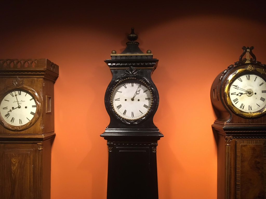 Several antique clocks near a bright wall