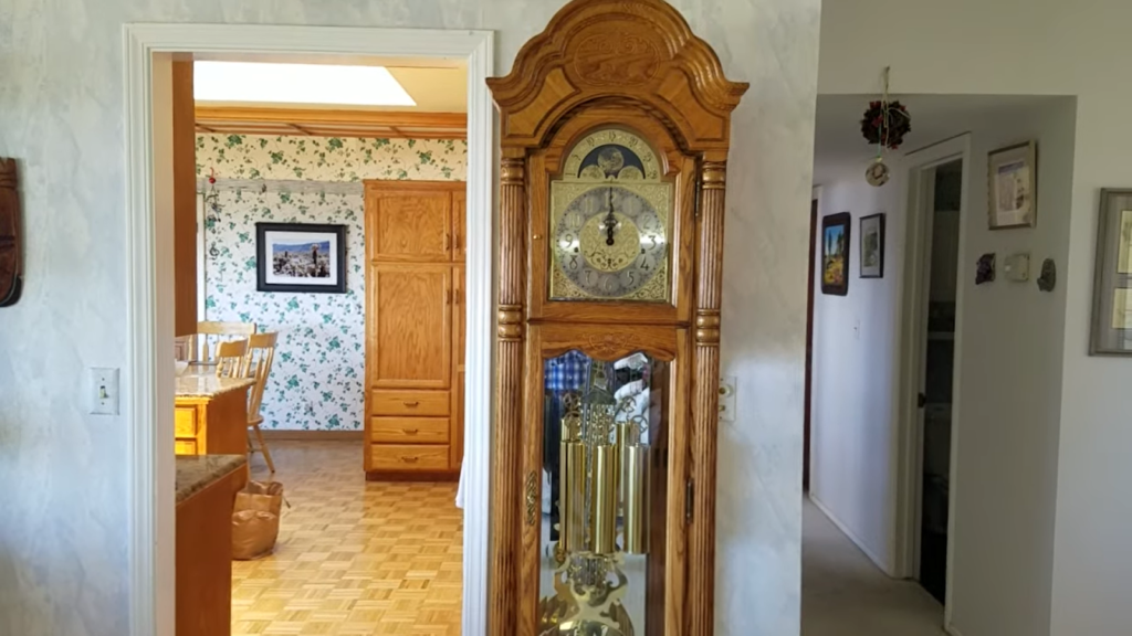 A grandfather clock with golden details in a traditionally decorated room