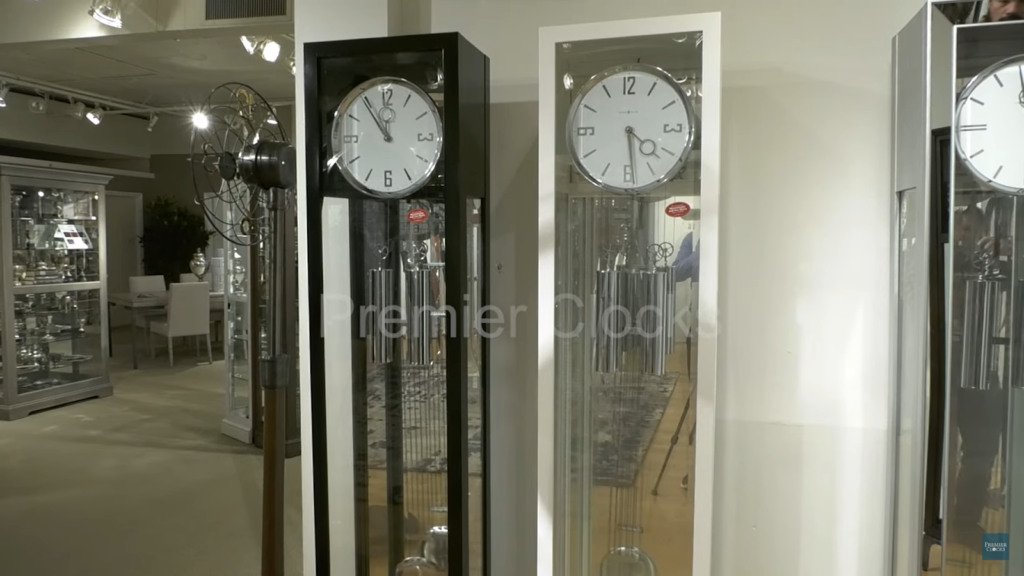 interior showroom with sleek standing clocks, a decorative metal fan, and glass cabinets filled with elegant tableware