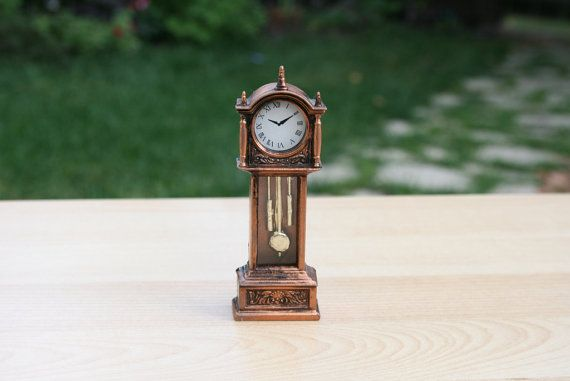 A small antique clock standing on the floor